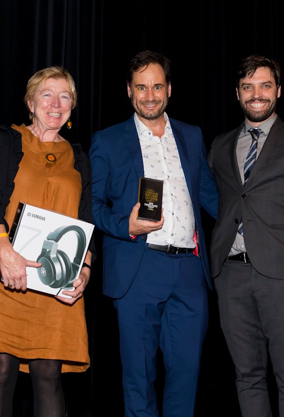 Wrong Skin consulting producer Siobhan McHugh and executive producer Greg Muller accept the award for Podcast of the Year from MC Tom Hogan.
