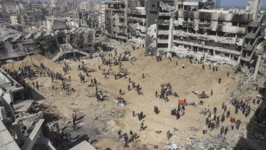 Palestinians walk through the destruction left by the Israeli air and ground offensive on the Gaza Strip near Shifa Hospital in Gaza City.
