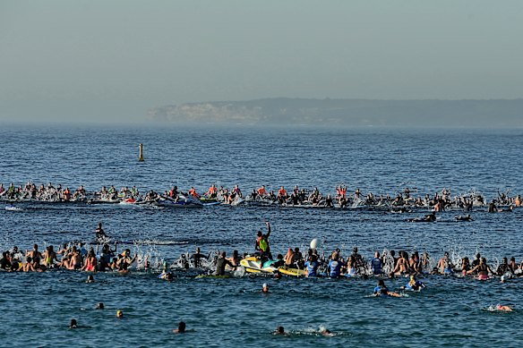 Hundreds of people form a circle and splash the water during the paddle-out.