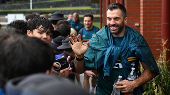 James Tedesco greets students at the Anglican Church Grammar School in Brisbane after kangaroos training on Monday.