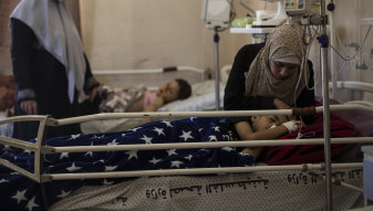 Yazan Al-zaharna, 9, is comforted by his mother in hospital, after he was wounded by an Israeli air strike on May 10. 