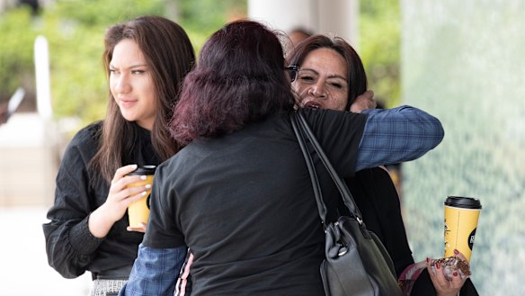 Family members hug outside the inquest.