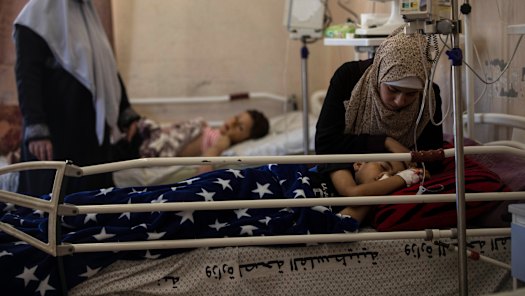 Yazan Al-zaharna, 9, is comforted by his mother in hospital, after he was wounded by an Israeli air strike on May 10. 