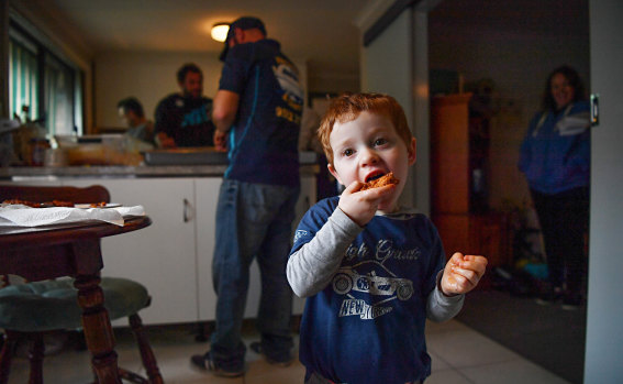 Jett Napoli, 3, taste tests some meatballs while family and friends make salami.