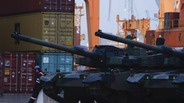 A worker stands next to South Korean Black Panther K2 tanks in the Polish port of Gdynia.