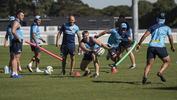 Tom Staniforth passes a ball as Waratahs players go through their paces at training in Sydney. 