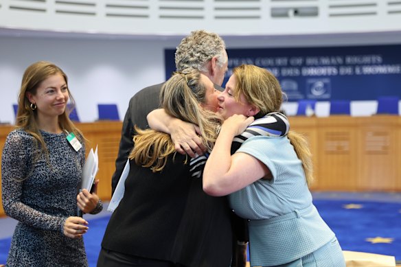Agent to the European Court of Human Rights for the Netherlands, Babette Koopman, right, hugs plaintiffs after the European Court of Human Rights issued its judgment.