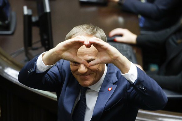 Donald Tusk shows a heart with his hands to lawmakers after he was elected as Poland’s prime minister in parliament in Warsaw on Monday.