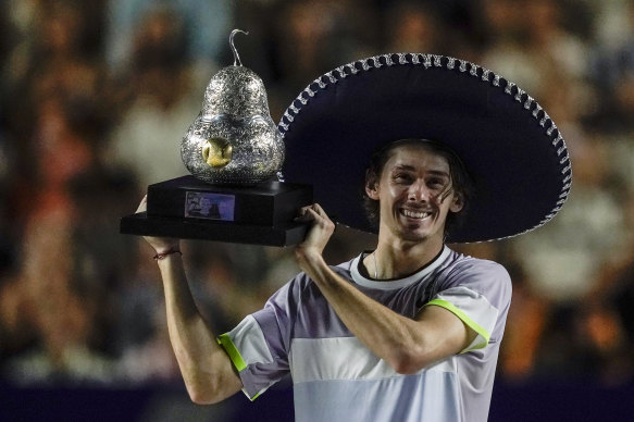 Alex de Minaur raises the trophy after the win.