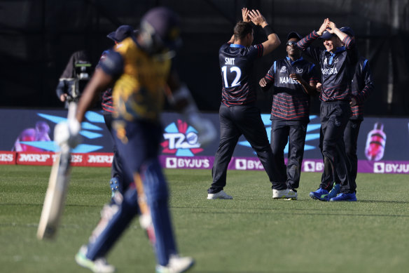 Namibia’s JJ Smit, centre, takes the wicket of Sri Lanka’s Chamika Karunaratne.