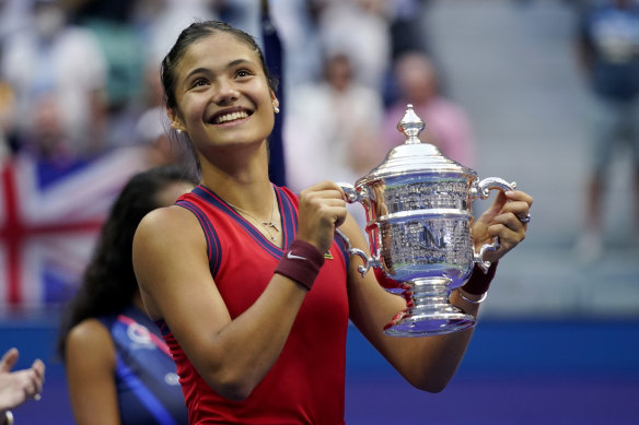 Emma Raducanu of Britain holds up the US Open championship trophy after defeating Leylah Fernandez of Canada.