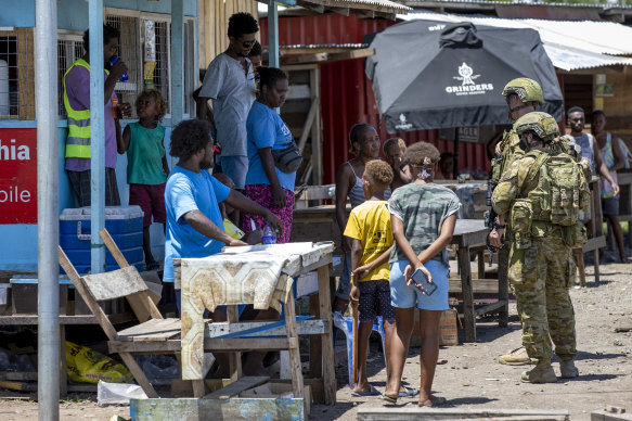 Australian Army soldiers talk with local citizens during a community engagement patrol through Honiara in November 2021.