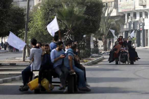 Palestinians on donkey carts hold up white flags trying to prevent being shot, while fleeing Gaza City on the al-Rimal neighbourhood, central Gaza City.