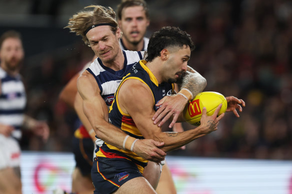 Tom Stewart of the Cats tackles Izak Rankine of the Crows.