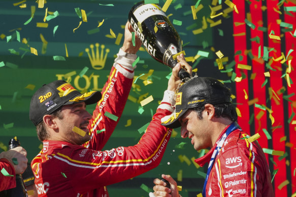 Second-placed Ferrari driver Charles Leclerc of Monaco pours champagne on teammate Carlos Sainz of Spain.