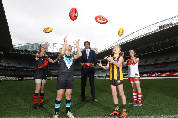AFL chief Gillon Mclachlan poses with young footballers Nora Don, Fadilla Taleb, Leni Burgoyne and Layla Rabah.