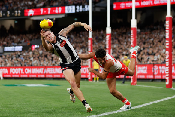 Jack Crisp of the Magpies and Justin McInerney of the Swans compete for the ball