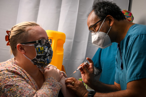 GP Mukesh Haikerwal administers a dose of Pfizer to Amanda Ashton.