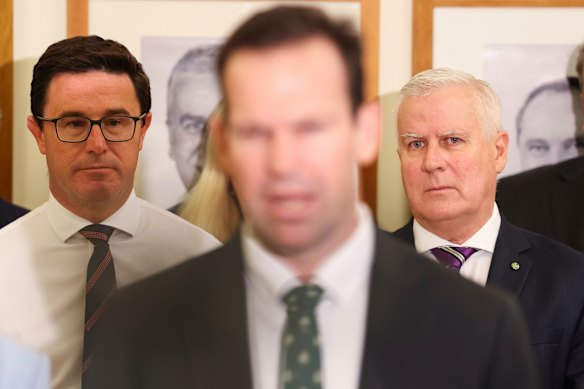 Matt Canavan, the new leader of the Nationals, flanked by two previous leaders, David Littleproud and Michael McCormack, in front of a wall of former leaders.
