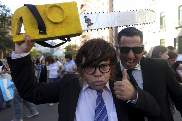 A supporter of Javier Milei holds a fake chainsaw during a campaign rally.