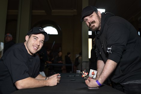 ‘It’s awesome’: Bombers star Zach Merrett, left, signs cards for collector James Vincent at the Hobby Hangout XL Trading Card Show.