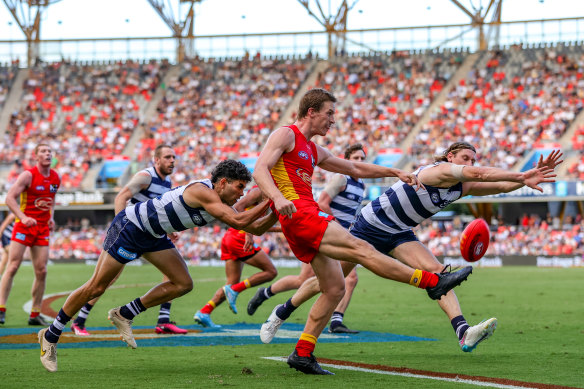 Noah Anderson kicks under pressure as the Suns score an upset win over Geelong in round three.