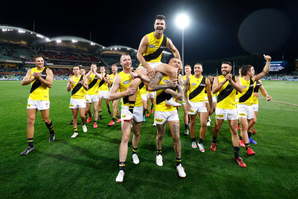 Trent Cotchin is chaired from the field by teammates Dylan Grimes (left) and Dustin Martin (right) after his 250th match in Richmond's preliminary final win over Port Adelaide.
