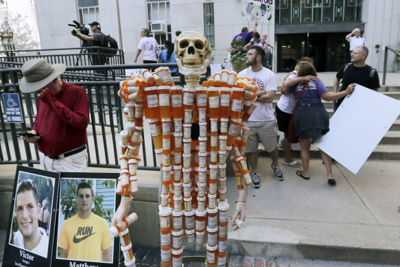 A skeleton made of pill bottles stands with protesters in August 2019 outside a court in Boston where a judge was hearing arguments against opioid maker Purdue Pharma.