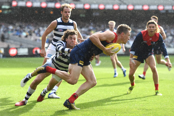 Tom McDonald looks to handball while under pressure from Brad Close and the Cats. 