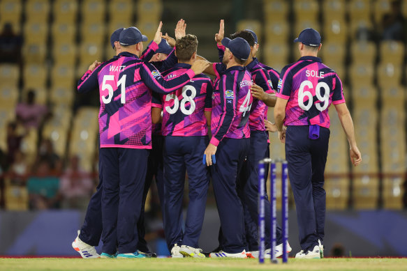 Scotland celebrate after claiming a wicket.