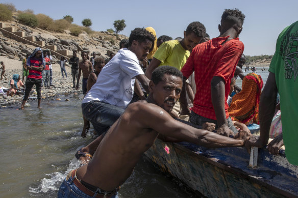 Tigray refugees who fled the conflict in the Ethiopia's Tigray ride a boat on the banks of the Tekeze River on the Sudan-Ethiopia border.