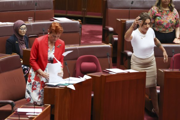 Independent senator Lidia Thorpe throws papers towards One Nation senator Pauline Hanson, as independent senator Fatima Payman watches on.