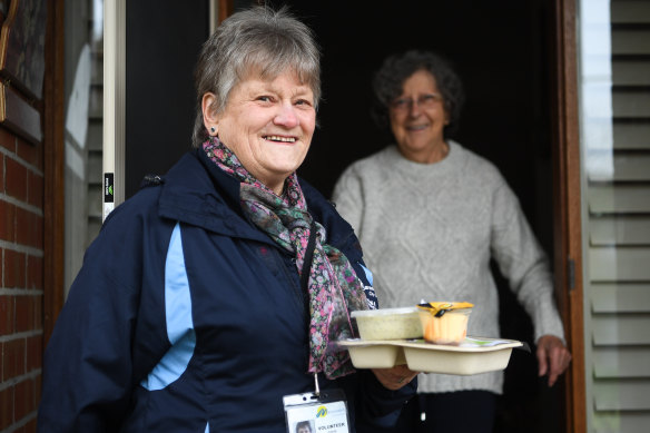 Adele Allen delivers a meal to Patricia Shing on Friday. She started doing deliveries for Meals on Wheels 50 years ago.