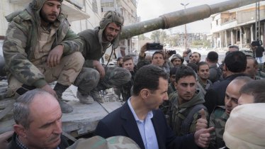 In this photo released on the official Facebook page of the Syrian Presidency, Bashar al-Assad speaks with Syrian troops in newly captured areas of eastern Ghouta. The image has not been independently verified.
