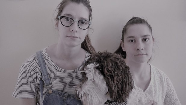 Hannah Forbes (right) and her sister Louise (left) are pleading with Brisbane dog owners to be vigilant, after their dog Harvey (middle) was poisoned in Teneriffe Park.