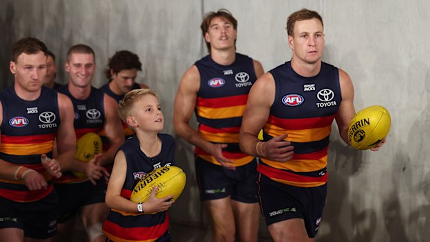Jordan Dawson of the Crows leads the team out.