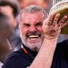 Tottenham head coach Ange Postecoglou holds up the Europa League trophy.