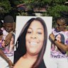 Family members hold aloft a photo of Ajike Owens at her memorial service.