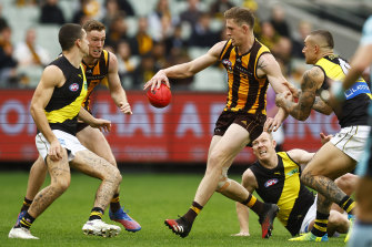 Sam Frost gets a kick while being tackled by Dustin Martin.