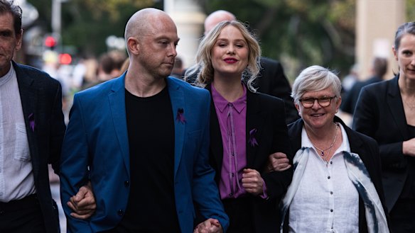 Ms Norvill leaves the Federal Court, linking arms with her supporters.