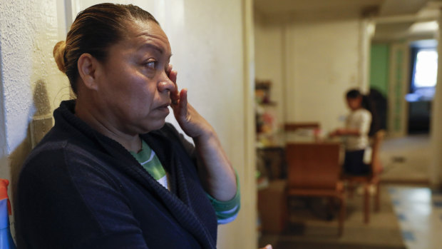 A woman in Washington wipes away tears as she worries about how to feed her family.