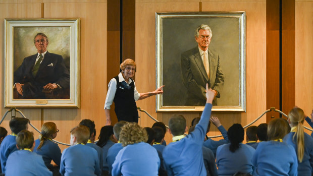 School children listen to a tour guide in front of the official portrait of the late PM Bob Hawke at Parliament House in Canberra.