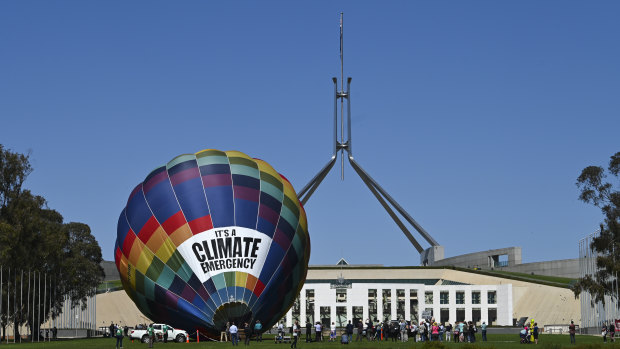 A climate change rally sets up outside Parliament House on Tuesday.