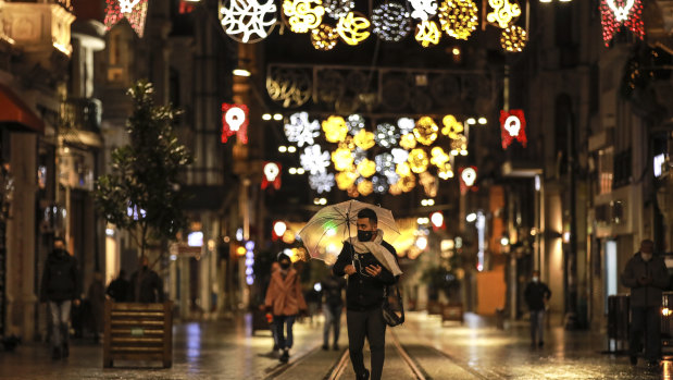 A few people walk in Istiklal street, the main shopping street in Istanbul, minutes into a coronavirus lockdown on Saturday.