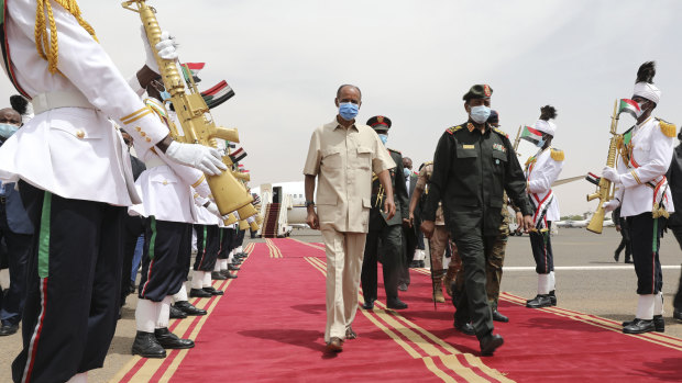 President of the Sudanese Transitional Council General Abdel Fattah al-Burhan, right, and Eritrean President Isaias Afwerki inspect a guard of honour at the Khartoum airport in Khartoum.