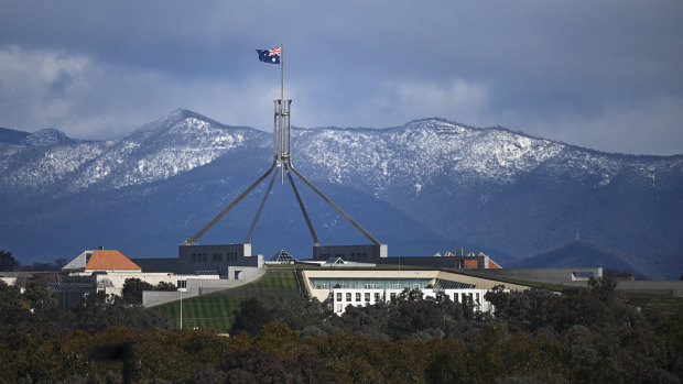 House of pain: Parliament House is seen in front of snow-covered hills surrounding the Australian Capital Territory.