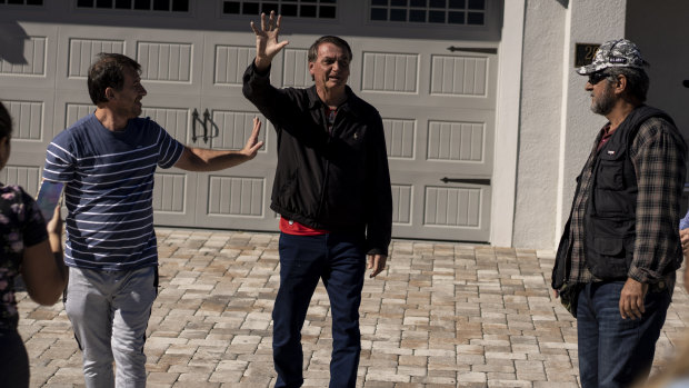 Former Brazilian president Jair Bolsonaro greets supporters outside the home where he’s staying in a resort community near Disney World in Kissimmee, Florida, the day before the riots.