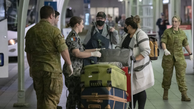 Passengers from San Francisco arrive at Sydney International Airport before being transported to hotel quarantine on Wednesday evening.