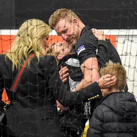 Collingwood coach Nathan Buckley being comforted by his family after the Pies loss.