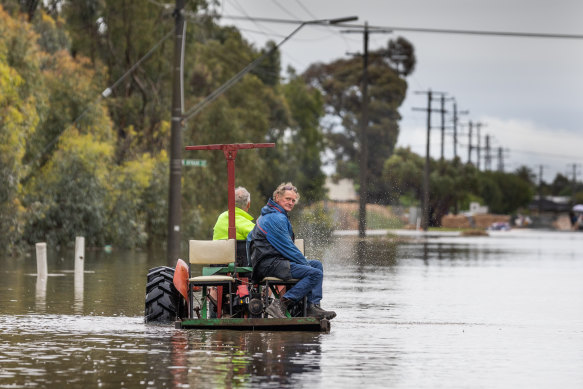 Ray Cross ferries a neighbour out of floodwater in Echuca East, in Victoria. 